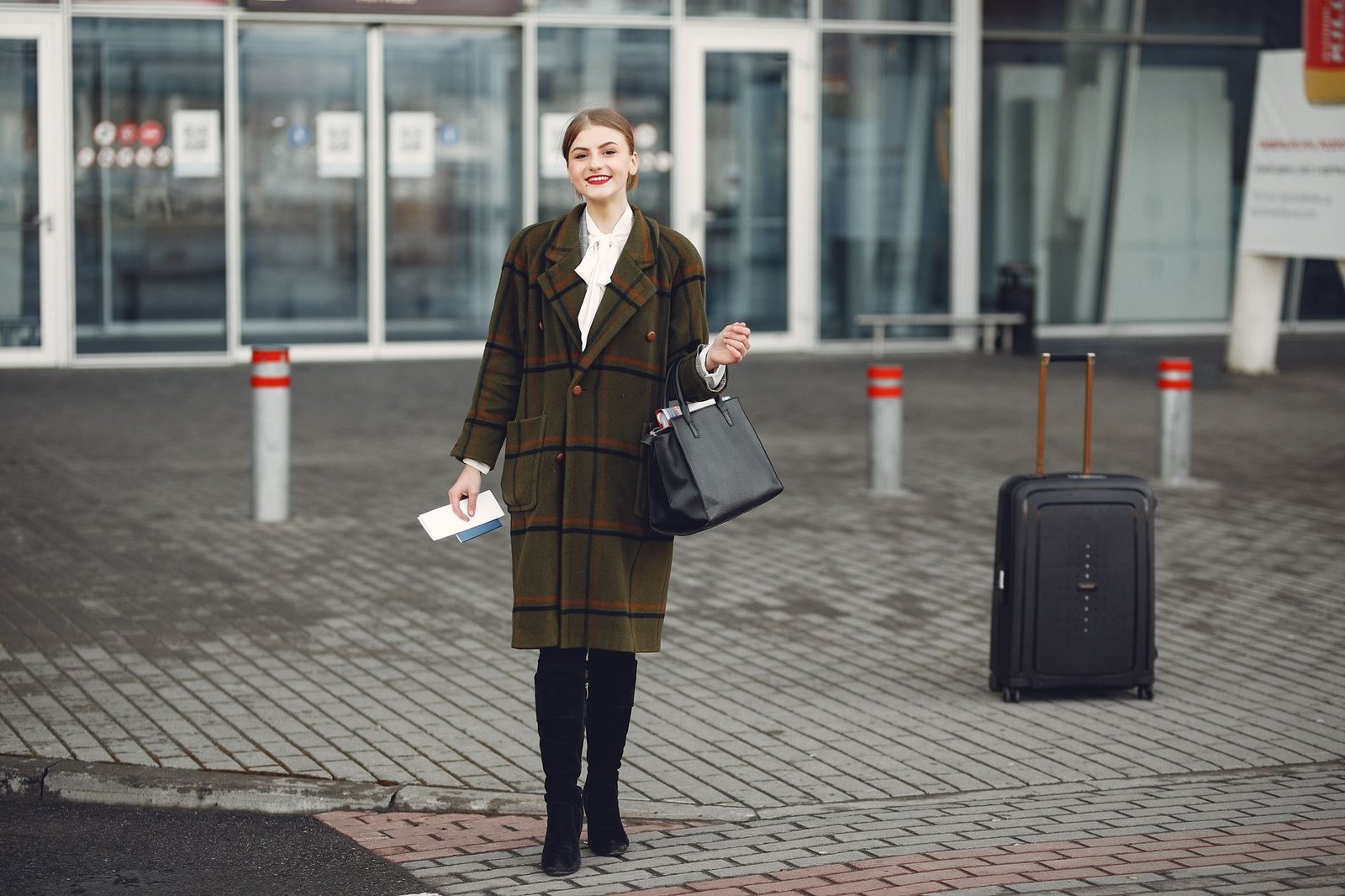 Woman in travel-ready outerwear holding a bag at an airport