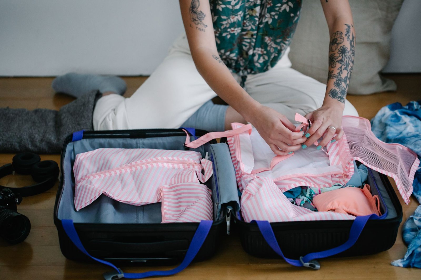 Hands folding clothing neatly into an open suitcase