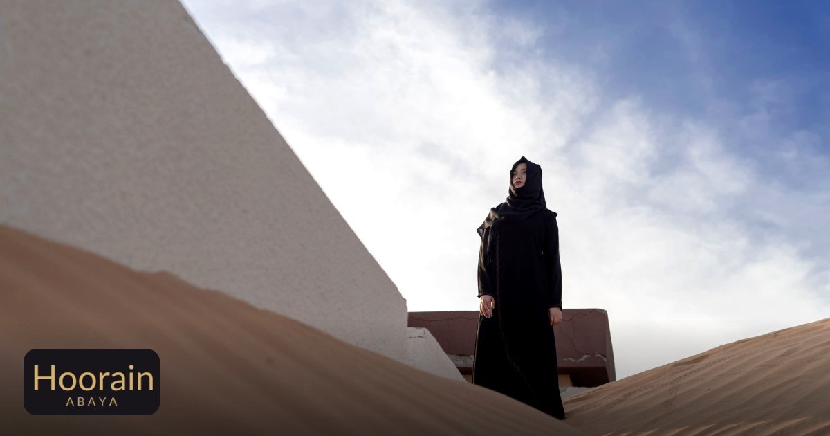 Best Abaya Fabric UAE Summer: The Complete Guide - a woman in traditional abaya standing on sand dunes in the desert
