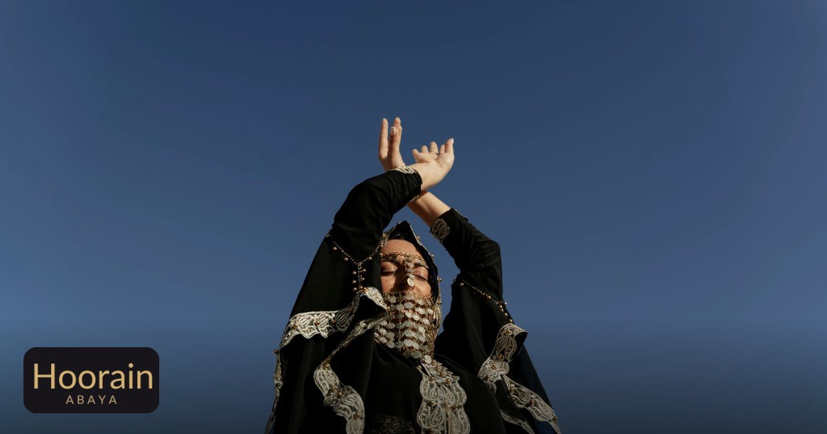 Embellished Abaya Guide: Crystal, Pearl, Embroidery - a woman in a decorative abaya raises her hands against a clear blue sky