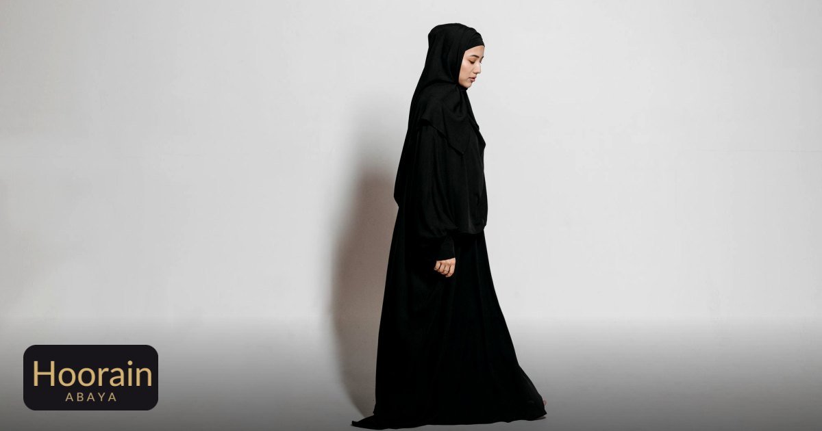 Open vs Closed Abaya: When to Wear Each - studio shot of a woman in traditional black abaya and hijab, eyes closed, side view