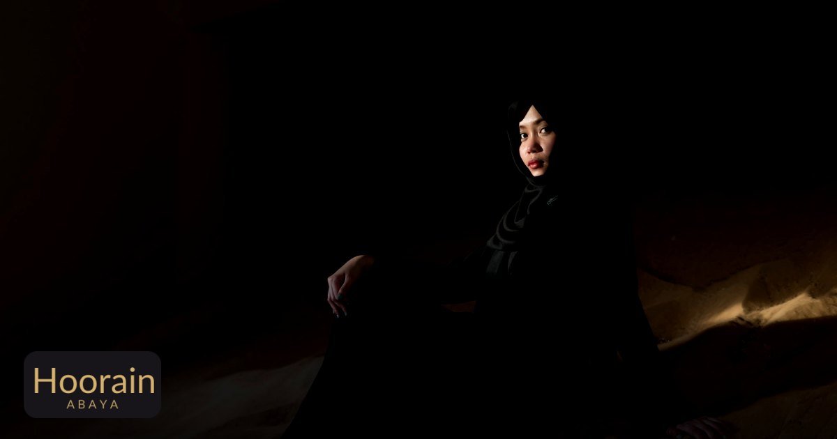 Versatile Abaya Styling Tips for Reversible Fashion - artistic portrait of woman in black abaya sitting on sand